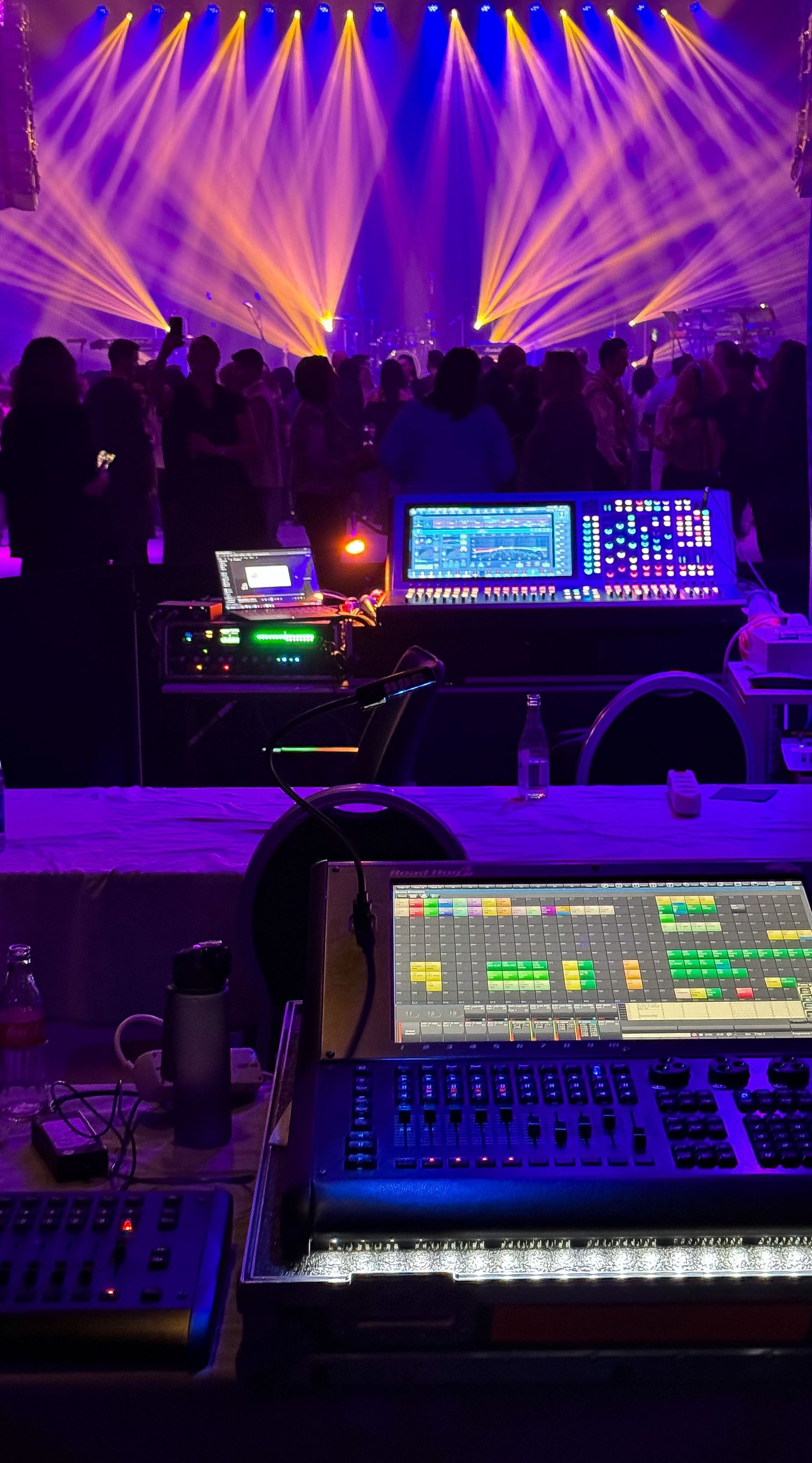 Dynamic concert scene with colorful stage lights and sound equipment.