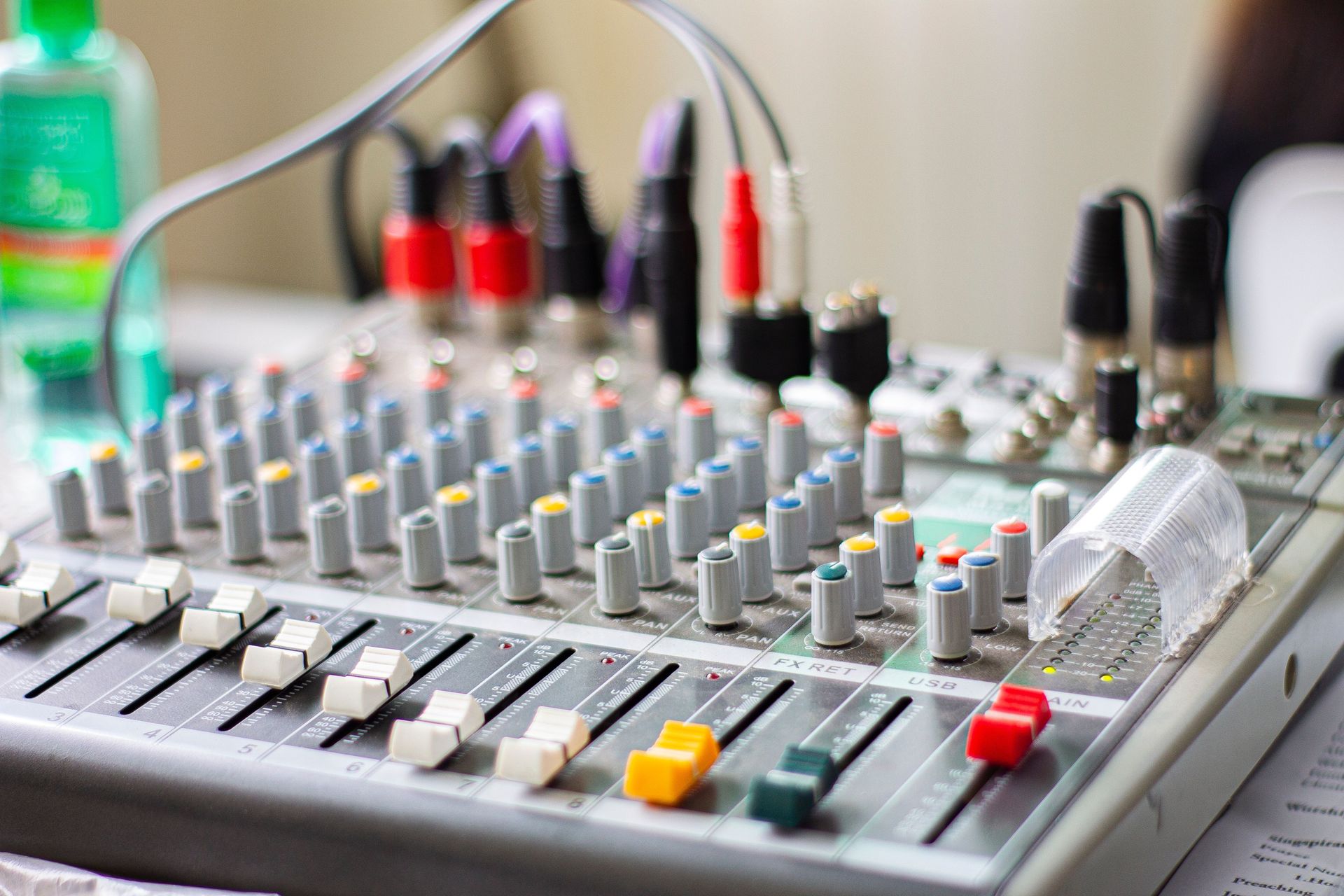 Colorful audio mixing console knobs and sliders in a professional music studio setting.